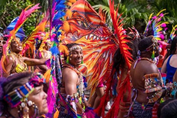 Carnival reveler in vibrant feathered headdress and beaded costume at Carnival in Bermuda