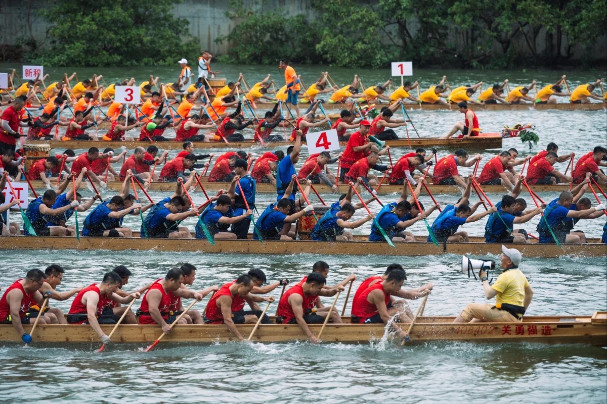 Synchronized dragon boat teams racing in Hong Kong, with twenty paddlers per vessel paddling to drum beats