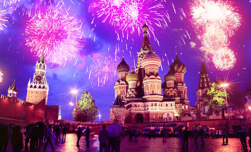 Fireworks over an illuminated cathedral and crowded plaza during a White Nights summer celebration in Russia